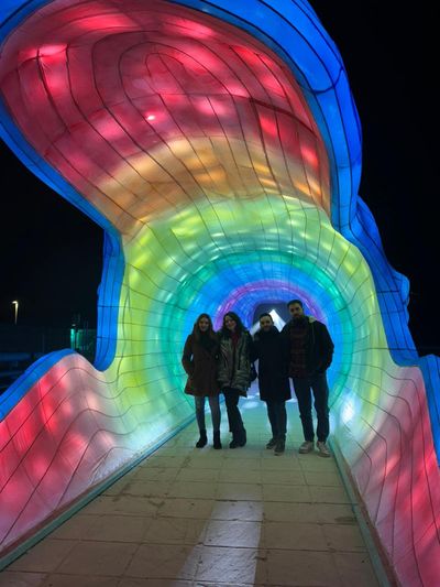 Inés con amigos en un pasillo iluminado